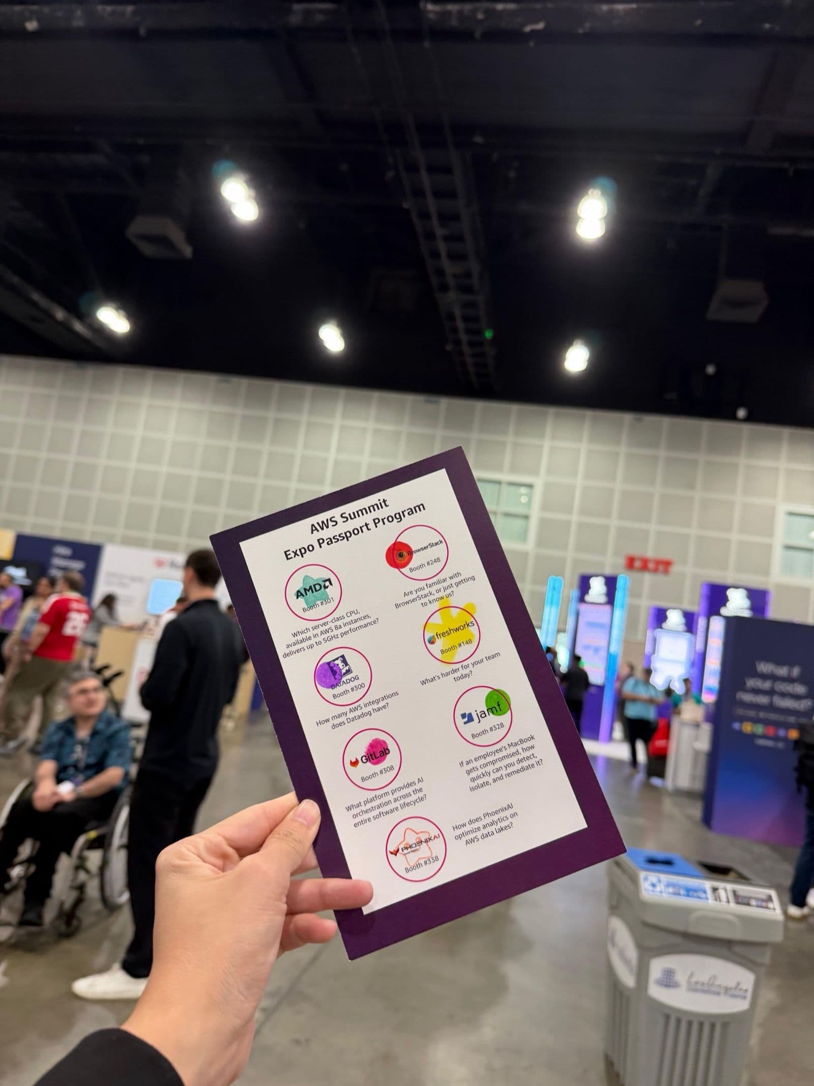 An AWS Summit Expo Passport held up inside the exhibition hall.